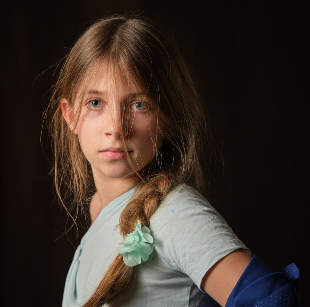 professional young girl portrait with great lighting, black background