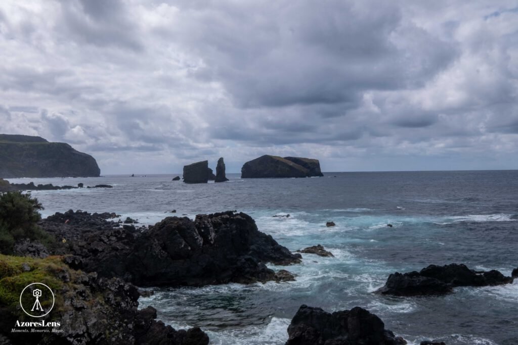 Panoramic view of Mosteiros and Ponta do Castelo on a cloudy day, where the dramatic sky meets the vast expanse of the Atlantic Ocean. The coastal charm of São Miguel, Azores, captured in this captivating and moody panoramic photo.