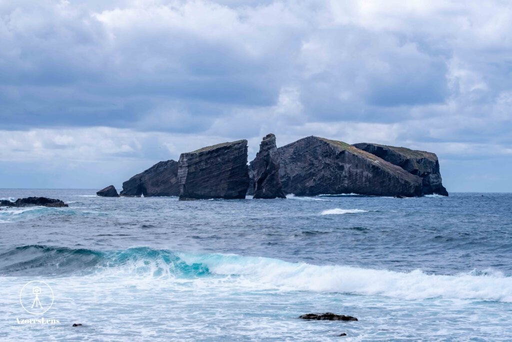 Panoramic view of Mosteiros and Ponta do Castelo on a cloudy day, where the dramatic sky meets the vast expanse of the Atlantic Ocean. The coastal charm of São Miguel, Azores, captured in this captivating and moody panoramic photo.