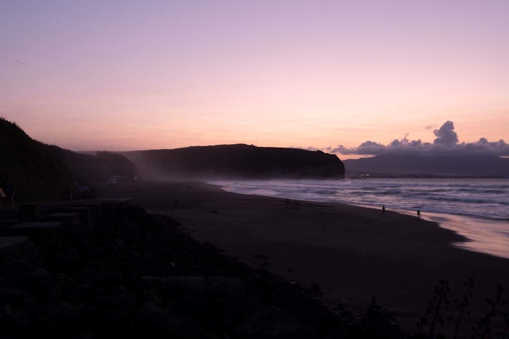 A breathtaking sunset over the beach, where gentle waves meet the shoreline, creating a serene and picturesque seascape. The warm hues of the setting sun cast a magical glow over the tranquil coastal scene.