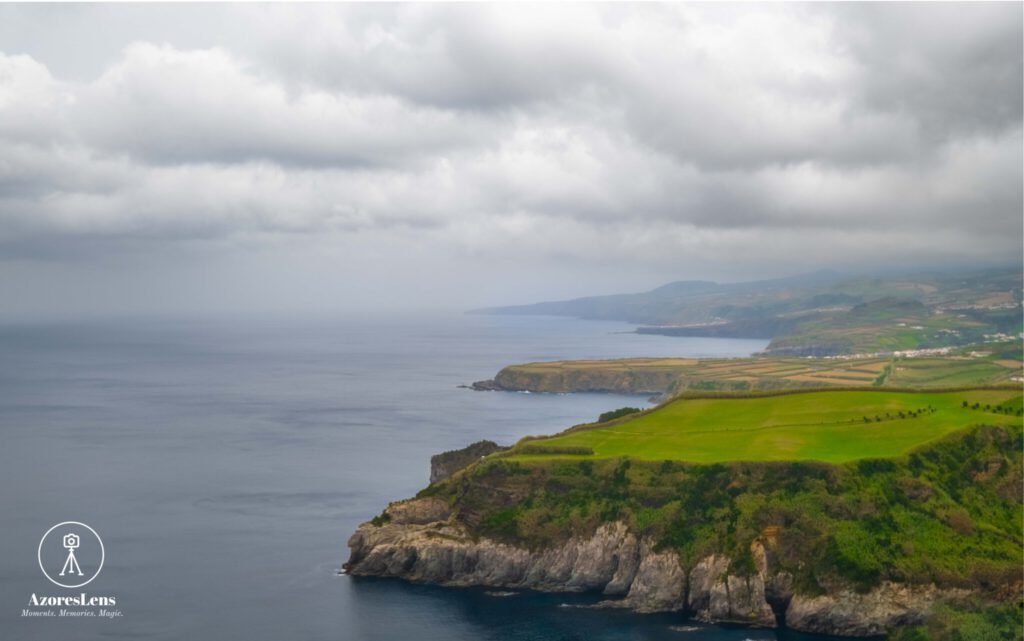 São Miguel's captivating volcanic landscape unfolds, harmonizing ocean views and rolling green hills on a cloudy day. A mesmerizing blend of natural elements on display, showcasing the unique beauty of this Azorean island.