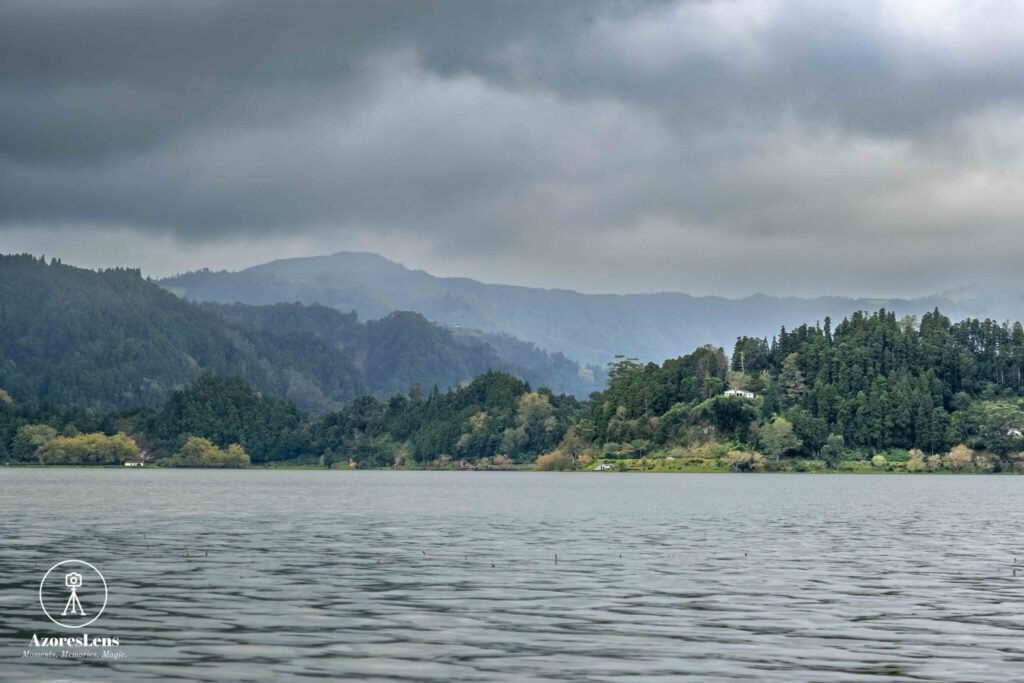 Enchanting scene of Furnas Lake surrounded by a lush green forest, shrouded in a mystical mist. A captivating glimpse into the tranquil beauty of São Miguel Island in the Azores.