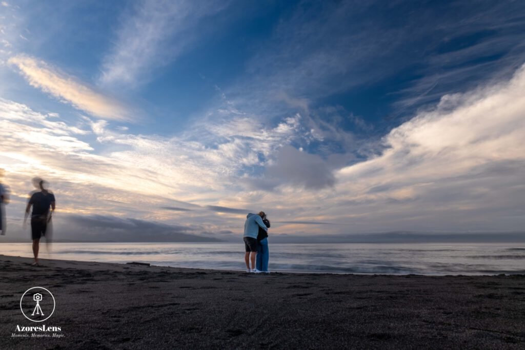 Romantic moment captured on the sandy shores of São Miguel Island. A love couple enjoys a peaceful beach day, framed by the breathtaking coastal beauty of the Azores.