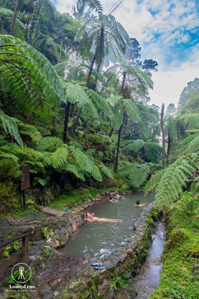 Caldeira Velha thermal bath oasis, surrounded by lush Azorean nature, outdoor activity Azores.. Relaxing hot spring experience amidst tropical greenery and cascading waterfalls