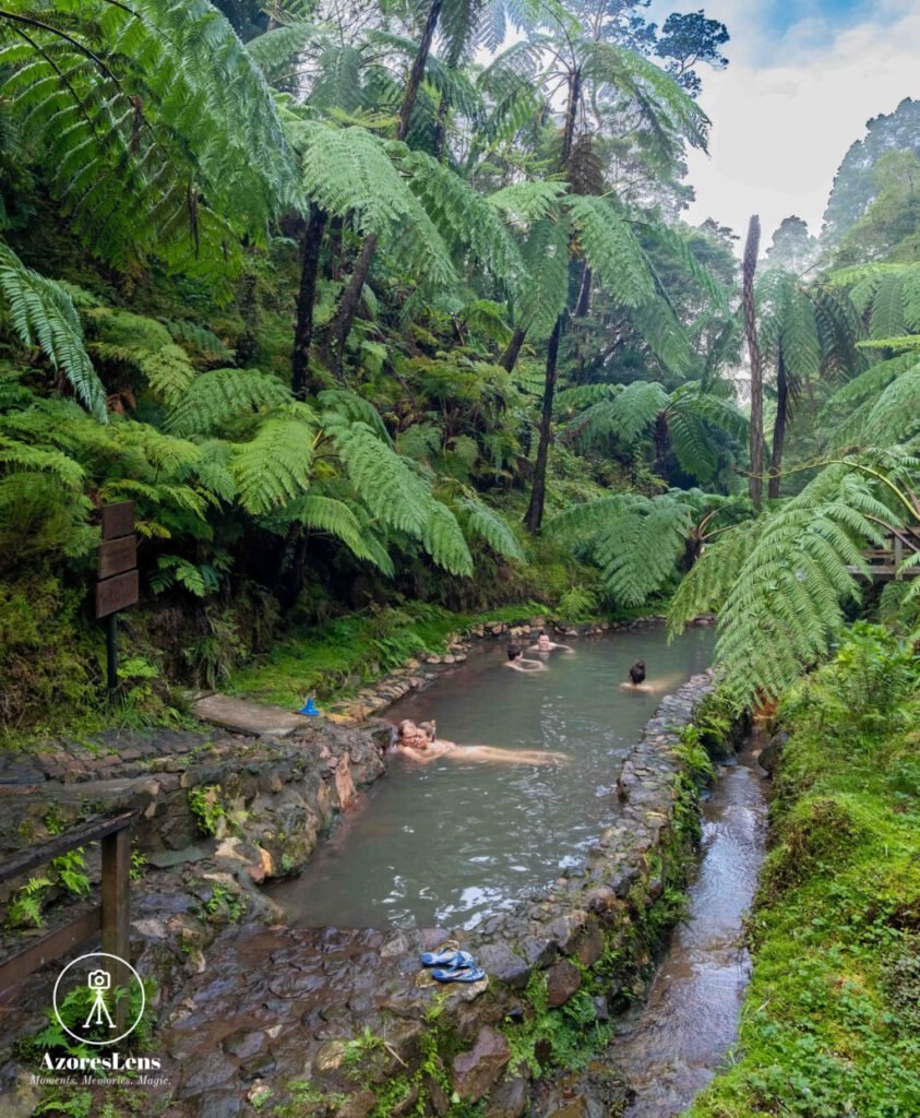 Sao Miguel Island, Azores, Caldeira Velha thermal bath oasis, surrounded by lush Azorean nature. Relaxing hot spring experience amidst tropical greenery and cascading waterfalls.