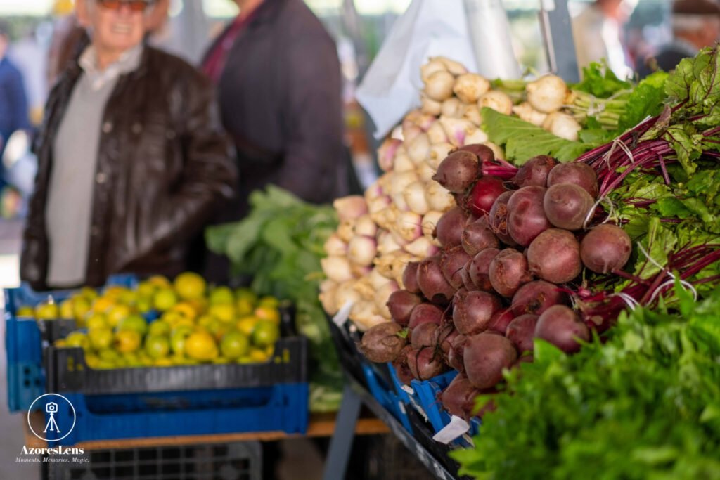 Vibrant scene at the weekly Azorean producers' market, showcasing locally grown and crafted goods. Colorful stalls filled with fresh fruits, vegetables, handmade crafts, and the bustling atmosphere of community connection.